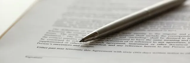Długopis leżący na zadrukowanej stronie z tekstem umowy