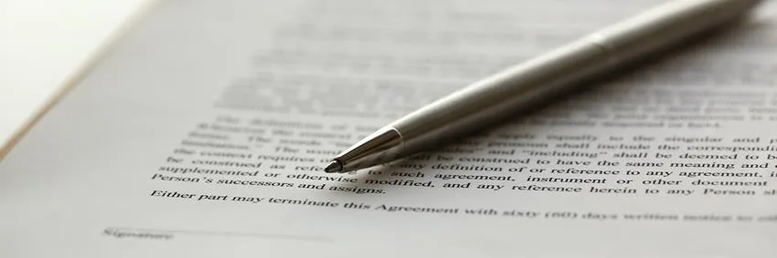 Długopis leżący na zadrukowanej stronie z tekstem umowy
