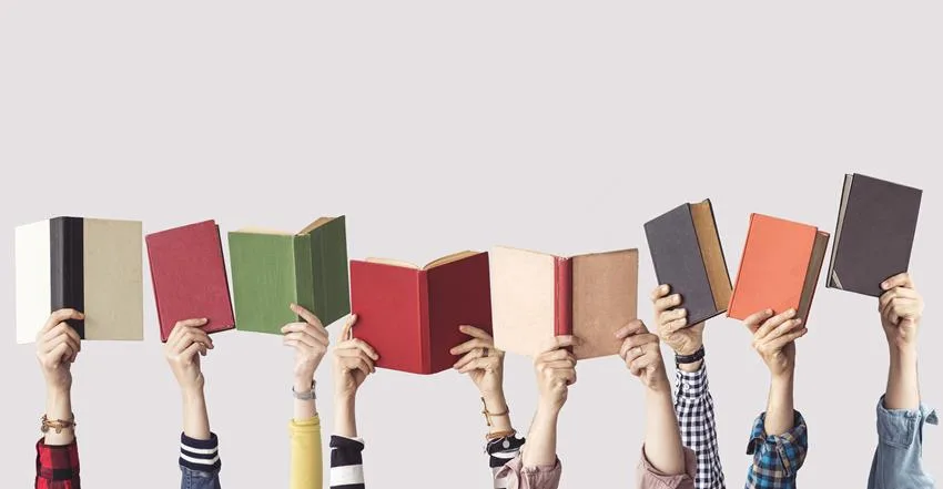 Rząd uniesionych dłoni trzymających otwarte książki